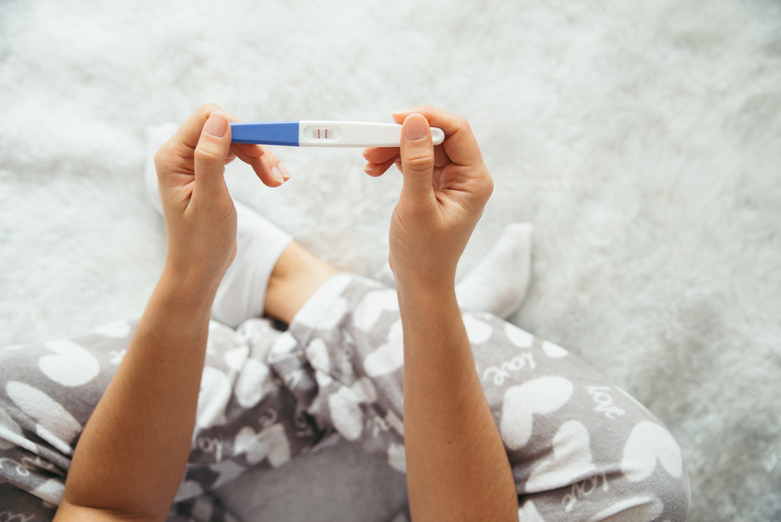 sad woman looking on pregnancy test unexpected