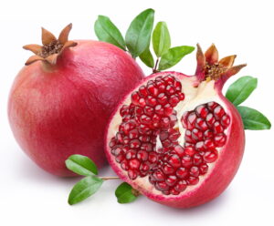 Juicy pomegranate and its half with leaves. Isolated on a white 